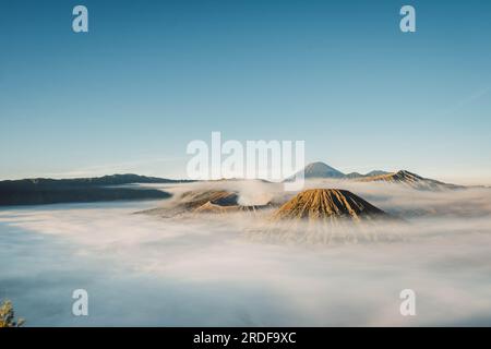 Gunung Bromo or Bromo Mountain is covered by clouds in the morning with clear blue sky Stock Photo