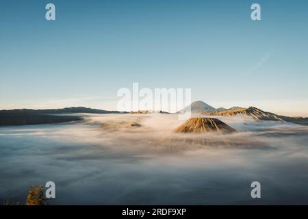 Gunung Bromo or Bromo Mountain is covered by clouds in the morning with clear blue sky Stock Photo