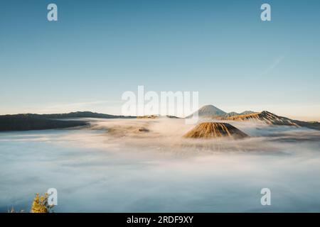 Gunung Bromo or Bromo Mountain is covered by clouds in the morning with clear blue sky Stock Photo