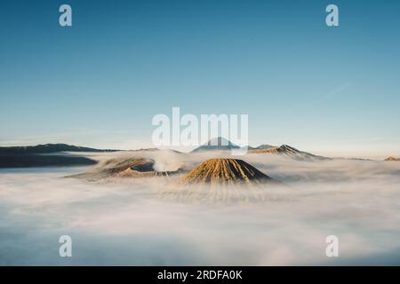 Gunung Bromo or Bromo Mountain is covered by clouds in the morning with clear blue sky Stock Photo