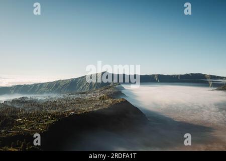 Cemoro Lawang village is covered by clouds near Mount Bromo viewed from Seruni Sunrise Point Stock Photo