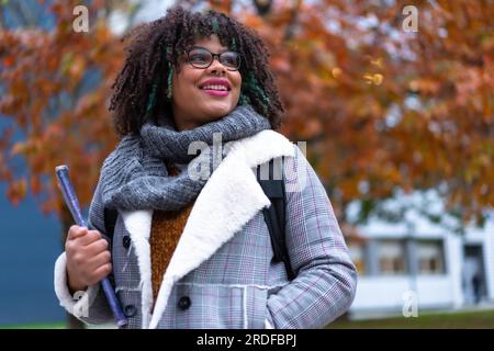 Portrait of black ethnic girl strolling in college college in fall back to school Stock Photo