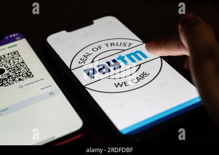 In this photo illustration, the Paytm logo and PhonePe QR code, is seen displayed on mobile phones screen in Guwanati, India on 19 July 2023. Stock Photo