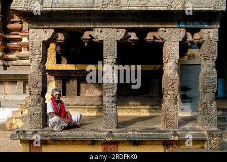 Old man sitting in front of Kandarathithan Gopuram in Virudhagireeswarar Shiva temple in Virudhachalam, Tamil Nadu, South India, India, Asia Stock Photo