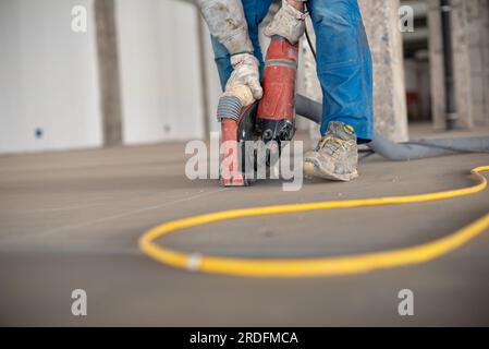 Crop site worker using concrete cutter Stock Photo
