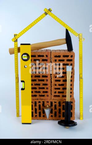 Brick, spirit level, hammer, chisel, plumb bob and scale, folding rule, folding ruler, cutout, object Stock Photo