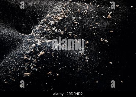 Abstract image made with flour and breadcrumbs on dark background. Conceptual image, alluding to space and cosmos, the unknown, light and darkness. Stock Photo