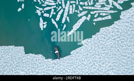 A cruising ship is anchored between pieces of ice in the arctic ocean near Svalbard. Stock Photo