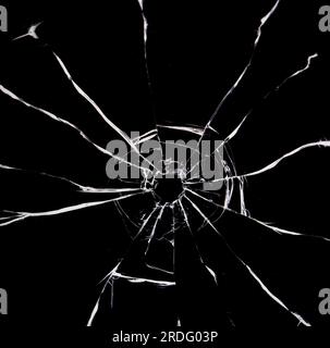 Texture of broken glass. Hole from a ball on a black background. Stock Photo
