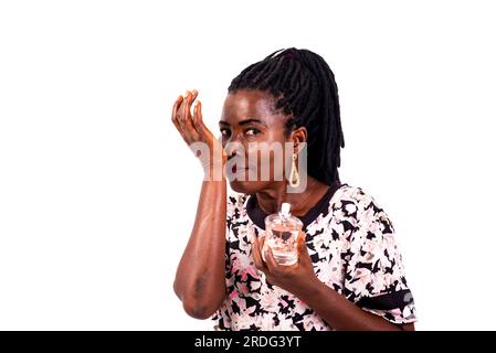 portrait of a beautiful mature woman smelling the perfume from her wrist smiling. Stock Photo