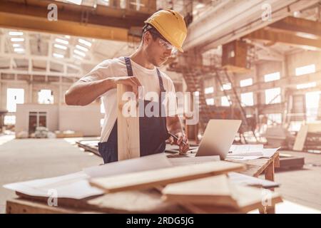 Handsome man builder using notebook at construction site Stock Photo