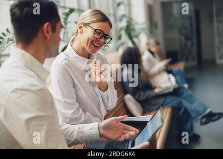 Woman office worker discussing new project with colleague during working day in coworking Stock Photo