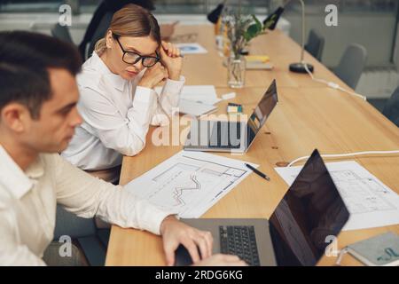 Two colleagues coworkers working together on new business plan during working day in office Stock Photo