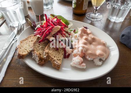 Open sandwich plate of prawns, brown bread, marie rose sauce and salad in an Irish seaside gastro pub restaurant Stock Photo