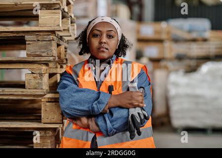 Portrait of young African American foreman looking at camera during her work in warehouse Stock Photo