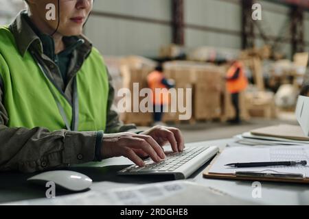 Close-up of foreman typing document on keyboard while sitting at her workplace and working on computer Stock Photo