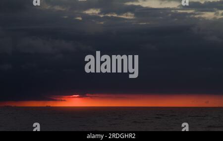 Sunset Behind Dark Threatening Stormy Sky Over The Wash, Snettisham, Norfolk UK Stock Photo