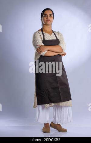 Indian women chef, potrait of a lady wearing apron with white background, isolated Stock Photo