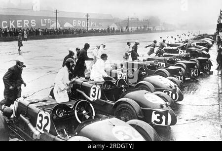 London, England:  c. 1931 Drivers sprinting to their race cars after the starting signal for the great International Double Twelve Hours Race at Brooklands Track. Fifty-one drivers competed, three of them women. Stock Photo