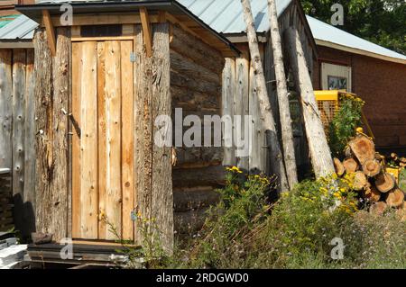 Rustic log sided, outhouse sits for sale in Upper Peninsula, Michigan. Stock Photo