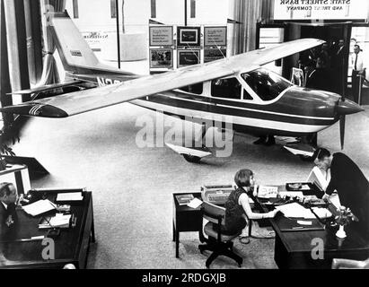 Boston, Massachusetts:  c. 1968 A new Cessna Cardinal sits in the lobby of the State Street Bank in Boston. Stock Photo