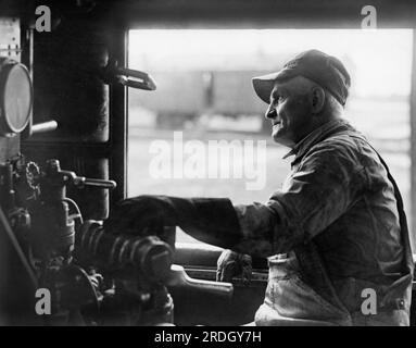 United States:  c. 1924 A train engineer looking out the window of his cab. Stock Photo