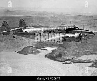 United States:  c. 1942  A Mid-Continent Airlines Lockheed L-18 Lodestar in flight over desert terrain, This operator was the first to use this type of aircraft in 1942. Stock Photo