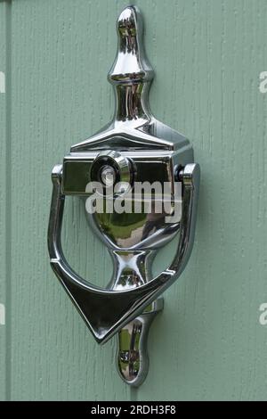 Closeup of ornate silver / chrome finish front door knocker with spy hole / peep hole viewer Stock Photo