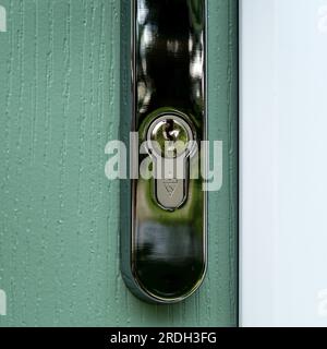 Closeup of British Standard kite marked pin tumbler euro profile cylinder lock fitted in silver front door handle. Stock Photo