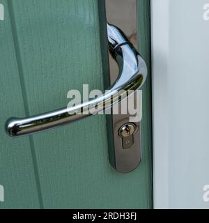 Kite marked pin tumbler euro profile cylinder lock fitted in silver / chrome finish front door handle. Stock Photo