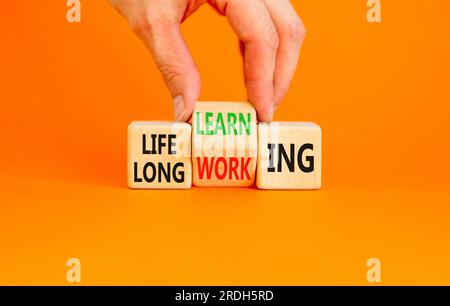 Lifelong learning working symbol. Concept word Lifelong learning working on block on a beautiful orange background. Businessman hand. Business educati Stock Photo