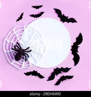 Composition of black bats and knitted spider with web with white round place for inspirational, motivational text. Halloween concept. Mockup for speci Stock Photo