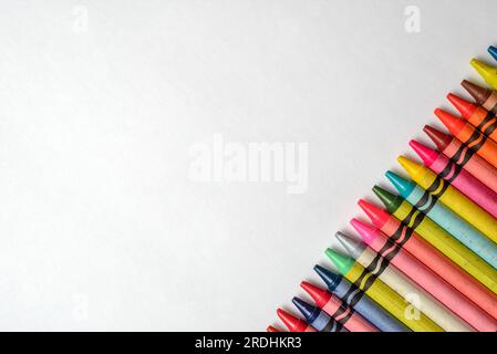 Multicolored crayons lined up on white background. Group of crayons of different colors. Stock Photo