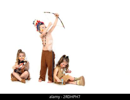 Adorable little indians go on the war path.  They are dressed in indian costumes and carry boy and tomahawks. Stock Photo