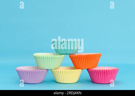 Paper molds for cupcakes on a blue background. Colorful molds. Stock Photo