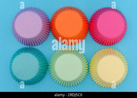 Paper molds for cupcakes on a blue background. Colorful molds. Stock Photo