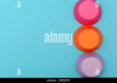 Paper molds for cupcakes on a blue background. Colorful molds. Stock Photo