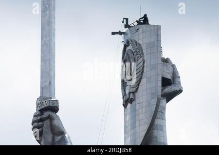 Kyiv, Ukraine. 21st July, 2023. Workers are seen preparing to dismantle the Soviet coat of arms from the shield of the Motherland sculpture in Kyiv. By the end of August 2023, the Ukrainian authorities plan to install the Ukrainian trident instead of the Soviet coat of arms on the shield of the famous statue. Ukraine has been actively conducting decommunization since 2014, refusing the names, symbols, and ideology of the Soviet era in all spheres of life. Credit: SOPA Images Limited/Alamy Live News Stock Photo