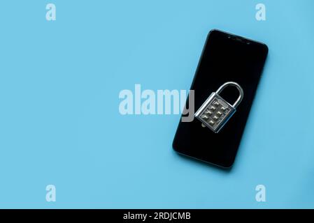 Mobile phone security concept. Data and privacy. Padlock over a smartphone on a blue background. Copy space, Stock Photo