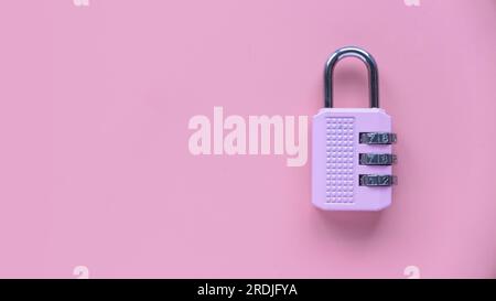 Safety and protection concept. Pink padlock isolated on a pink background with copy space. Stock Photo