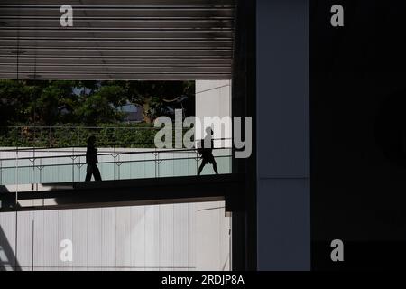 People in silhouette on a raised walkway in a building in Shinjuku, Tokyo, Japan. Stock Photo