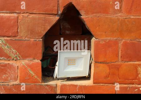 Foot light or spot light kept inside niche of a brick wall to give a classic look , foot light for gardens. Stock Photo