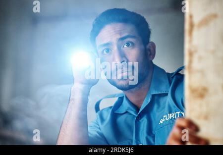 Flashlight, security guard and man in dark room for investigation, inspection and property search at night. Surveillance, law and police officer with Stock Photo