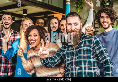 Multiethnic joyful university students or young business people looking at camera with victory gestures for a group photo - Goal achievement concept Stock Photo