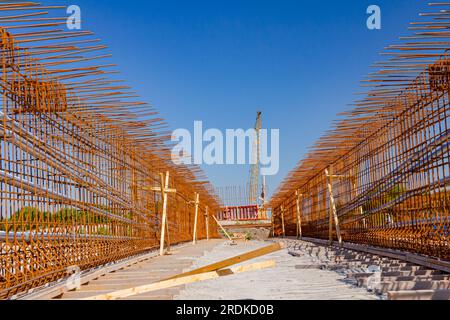 Girder, bridge skeleton, reinforcement, installed vertical crossed rusty armature rods on the building site. New road is under construction. Stock Photo