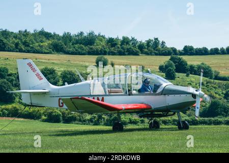 A small tug aircraft manoeuvre into position on the runway at a small aIrport in the south of England UK Stock Photo