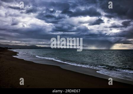 Winter beach scene, Torremolinos, Costa del Sol, Spain.  Approaching rain sqaull over sea. Stock Photo