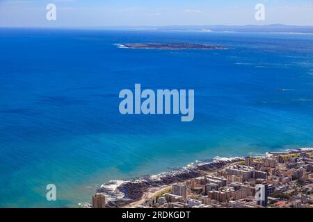 Photo of Robben Island prison from Lions Head during the day in blue skies with a city section of Cape Town photographed in South Frika in September 2 Stock Photo