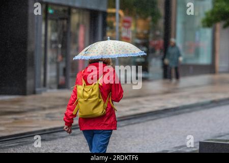 Preston Lancashire.  UK Weather 22 July 2023. Summer sales, shops, and shoppers on a rainy day in the city centre. Forecasters say: 'Rain, heavy at times, through Saturday & Sunday is likely to cause some disruption, particularly to outdoor events. Credit: MediaWorldImages/AlamyLiveNews Stock Photo