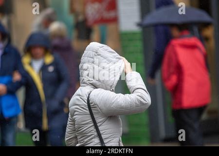 Preston Lancashire.  UK Weather 22 July 2023. Summer sales, shops, and shoppers on a rainy day in the city centre. Forecasters say: 'Rain, heavy at times, through Saturday & Sunday is likely to cause some disruption, particularly to outdoor events. Credit: MediaWorldImages/AlamyLiveNews Stock Photo